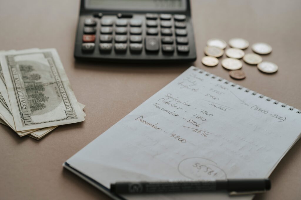 Escritorio con calculadora, billetes, monedas y notas financieras para planificar presupuesto mensual