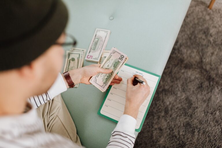 Persona organizando finanzas personales con billetes y calculadora para hacer un presupuesto mensual