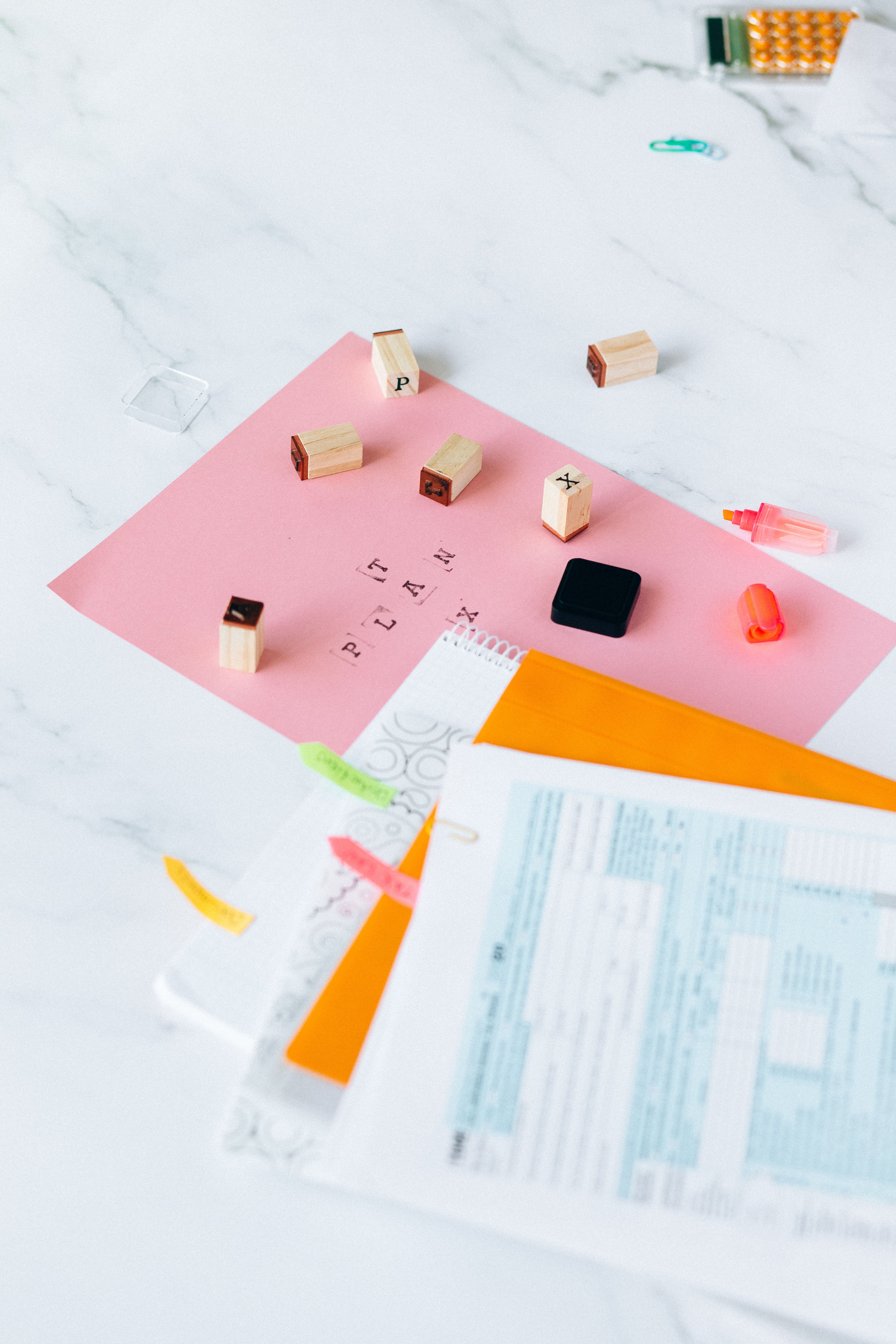 Formas fiscales y timbres de goma sobre un escritorio de marmol — Foto de N. Voitkevich en Pexels (https://www.pexels.com/photo/tax-return-form-and-notebooks-on-the-table-6863508/)