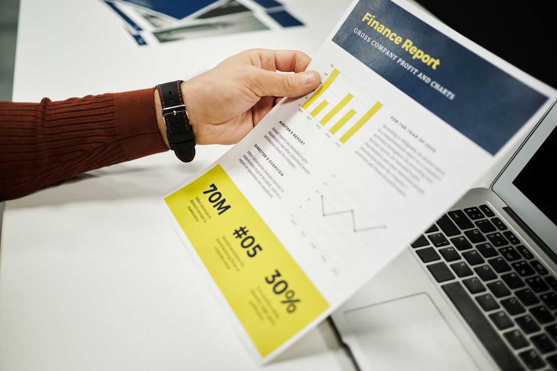 Persona analizando reporte financiero con gráficas en escritorio