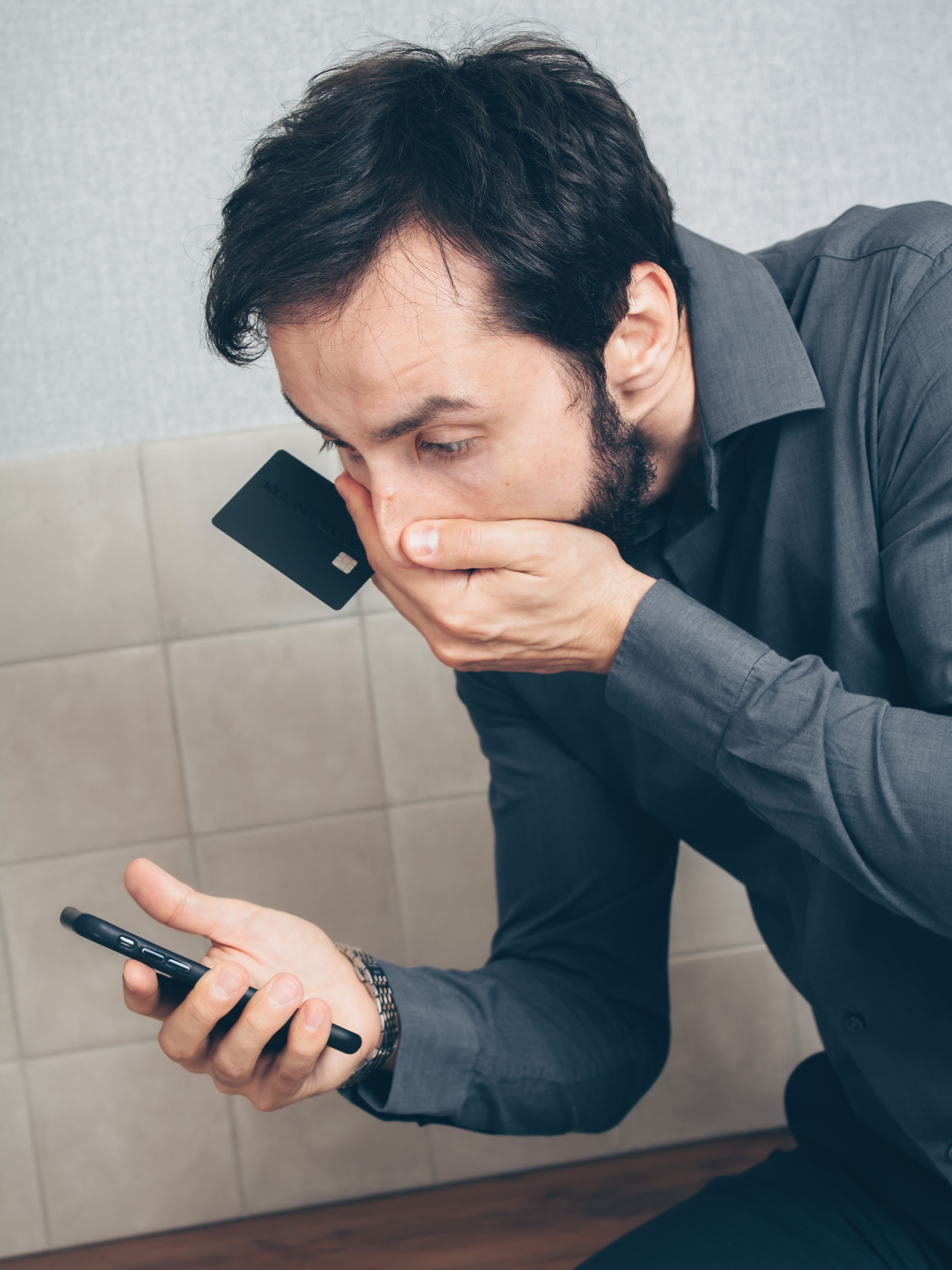Persona revisando notificación de transferencia bancaria en smartphone con tarjeta